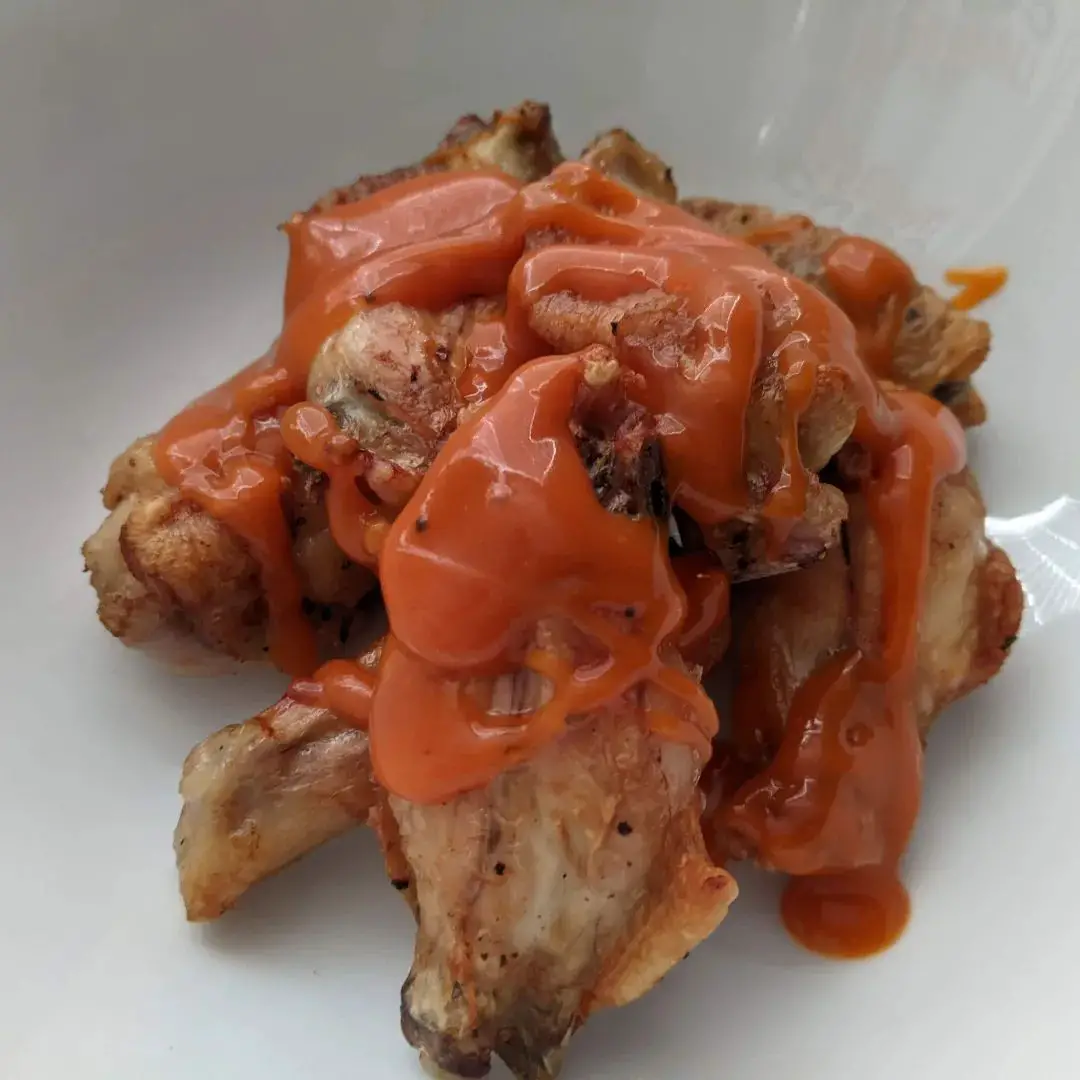 Wings drizzled in hot sauce.